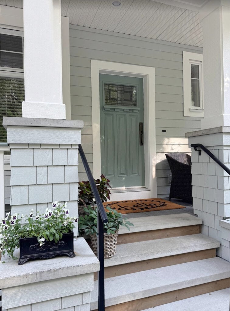 Benjamin Moore Gray Horse, light gray green exterior, Rushing River soft teal blue-green front door, Pure White trim. Gray shakes