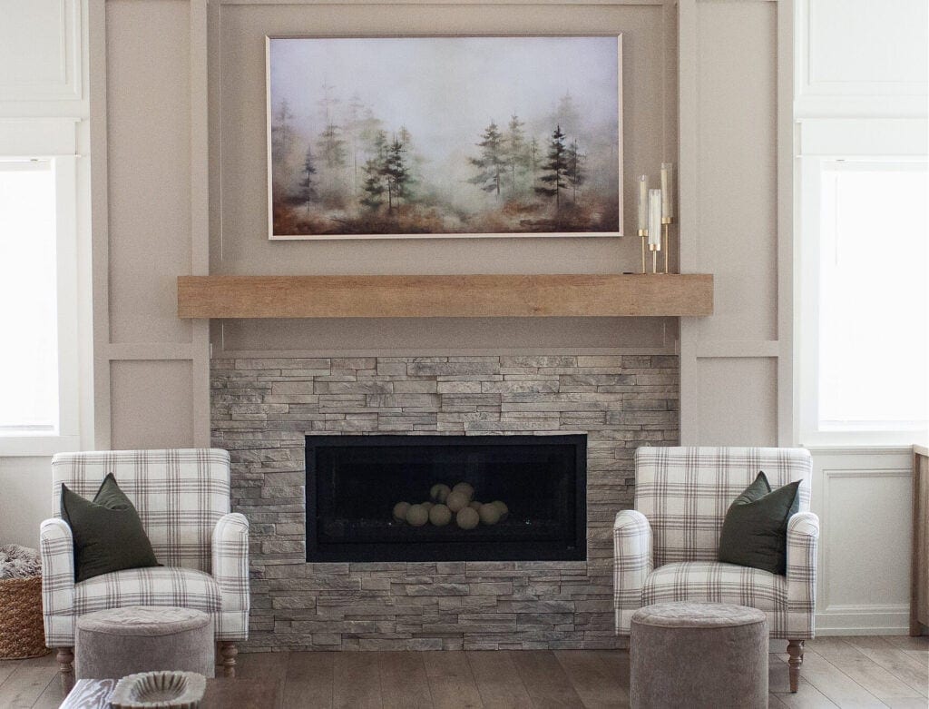 Fireplace-update-ideas-stacked-stone-in-gray-beige-wood-mantel-moldings-trims-added-in-Sherwin-Williams-Balanced-Beige-Graywash-LVP-flooring-accent-chairs-Living-room-scaled