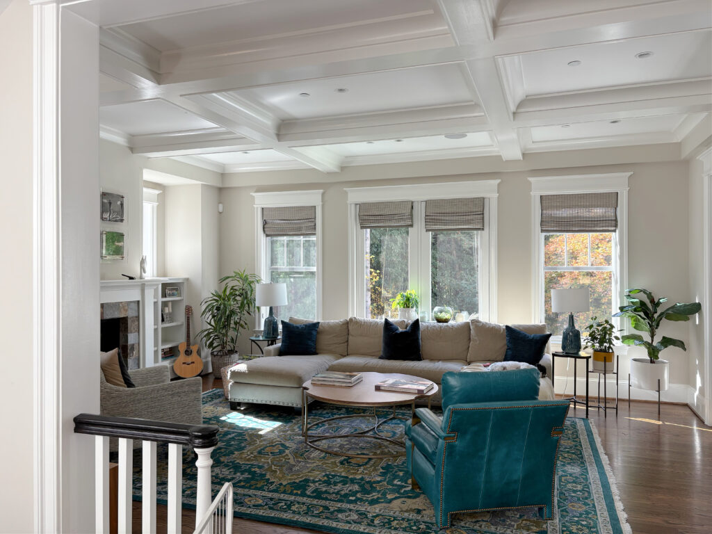 Large living room painted Benjamin MOore Edgecomb Gray, teal blue accents and dercor, oak floor, White Dove trims and coffered ceiling