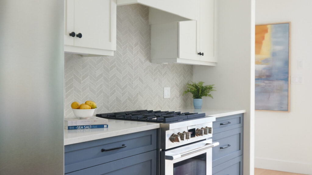Benjamin Moore White Dove on painted cabinets, chevron tile backsplash, Fulgor appliances, Brittania Blue on lower cabinets, white oak floor, stainless