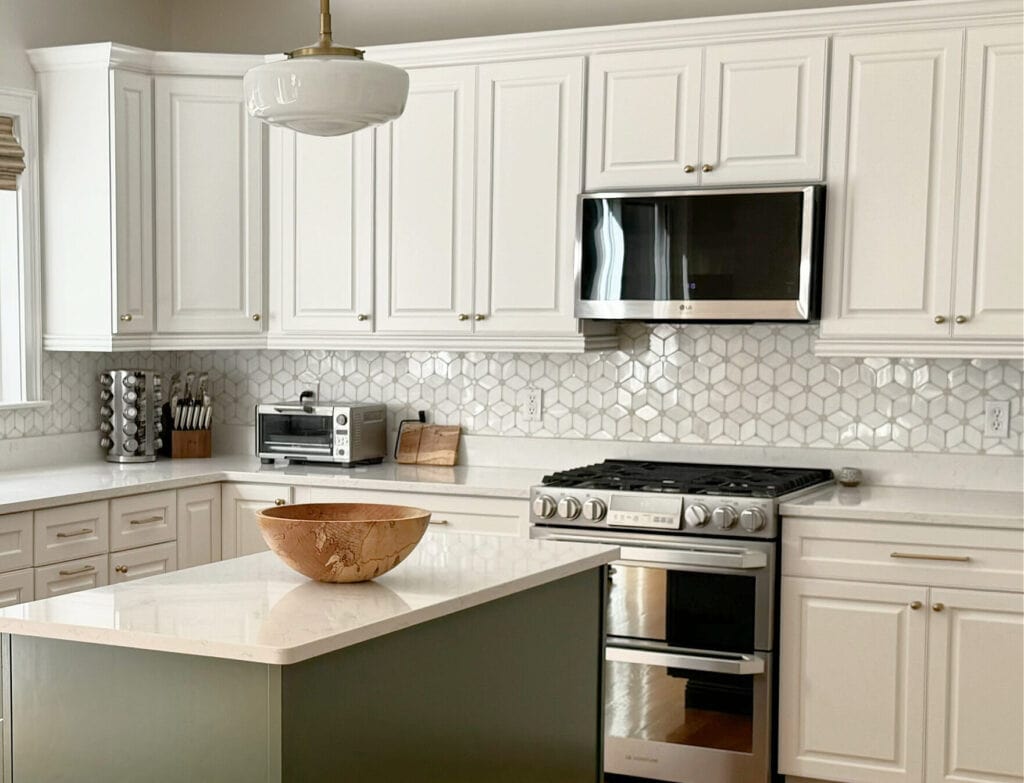 Benjamin Moore White Dove painted kitchen wood cabinets, Peale Green island, white quartz, patterned tile marble backsplash, golden oak flooring, Pearly White (Sherwin) walls