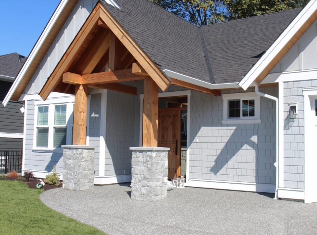 James Hardie LIght Mist exterior shake and board and batten, fir beams around front door, gray stone, High Reflective White trim, white windows, dark gray asphalt roof. Wood soffits