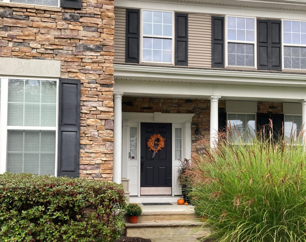 Sherwin Williams Darkroom, dark purple painted front door with orange exterior stone