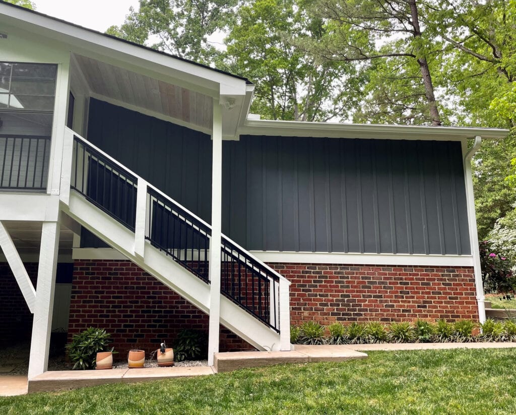 Sherwin Williams Extra White trim and exterior railings. James Hardie Iron Gray dark gray-blue-green siding color, red brick