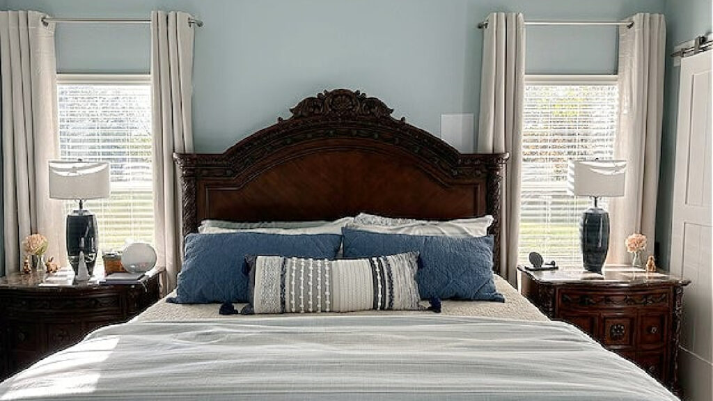 Sherwin Williams RAin, a blue paint color on bedroom walls with red-stained wood furniture