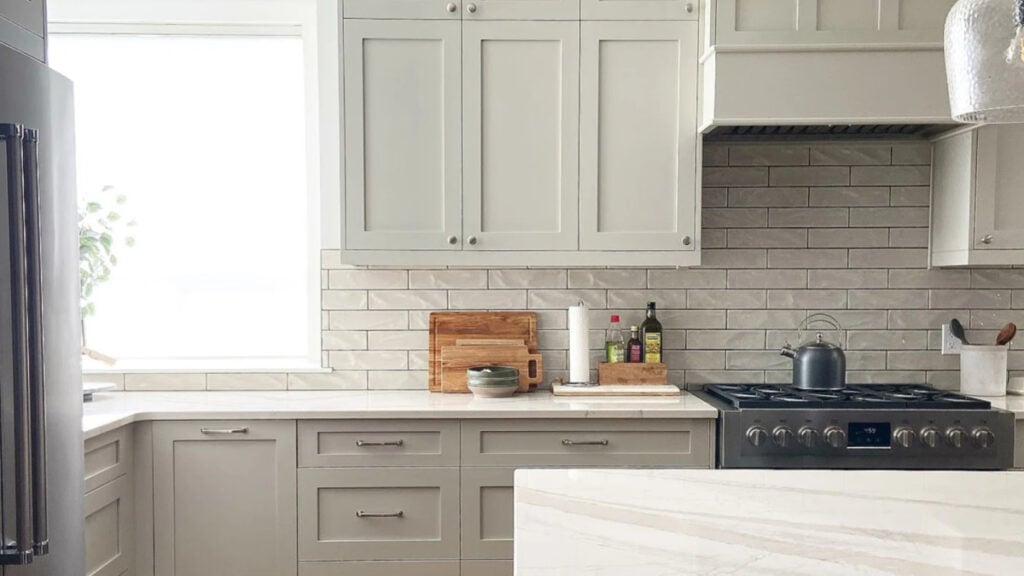 BEnjamin moore Revere Pewter kitchen cabinets with warm gray or greige subway tile backsplash (1)