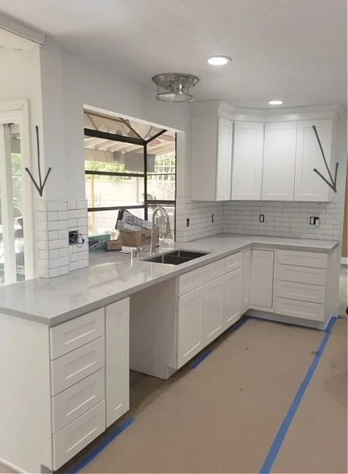 Benjamin Moore Chantilly Lace with white subway tile that extends past the upper cabinets and stops with the counter