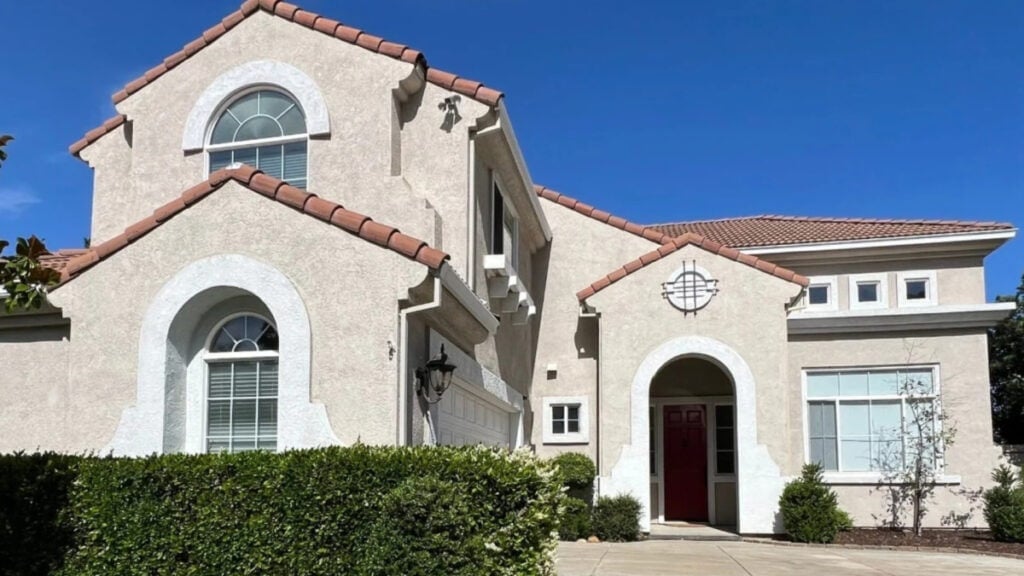 Florida or Arizona style red clay tile roof with warm paint color on the stucco and white trim, wood stained front door and garage door. Stucco trim and white windowsjpg