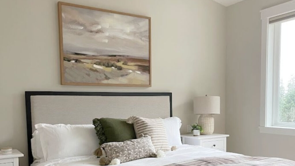 Sherwin Williams Aesthetic White in bedroom with beige upholstered headboard and neutral linens