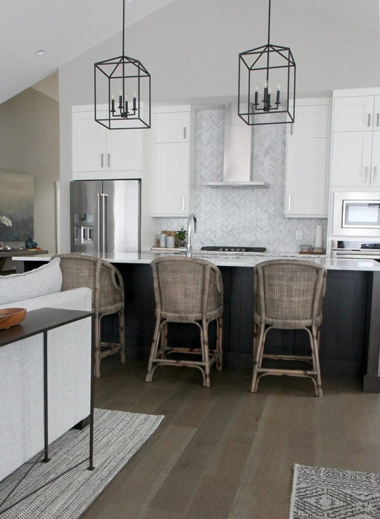 Sherwin Williams Alabaster or similar painted kitchen cabinets, herringbone marble tile backsplash, chimney range hood and dark wood island