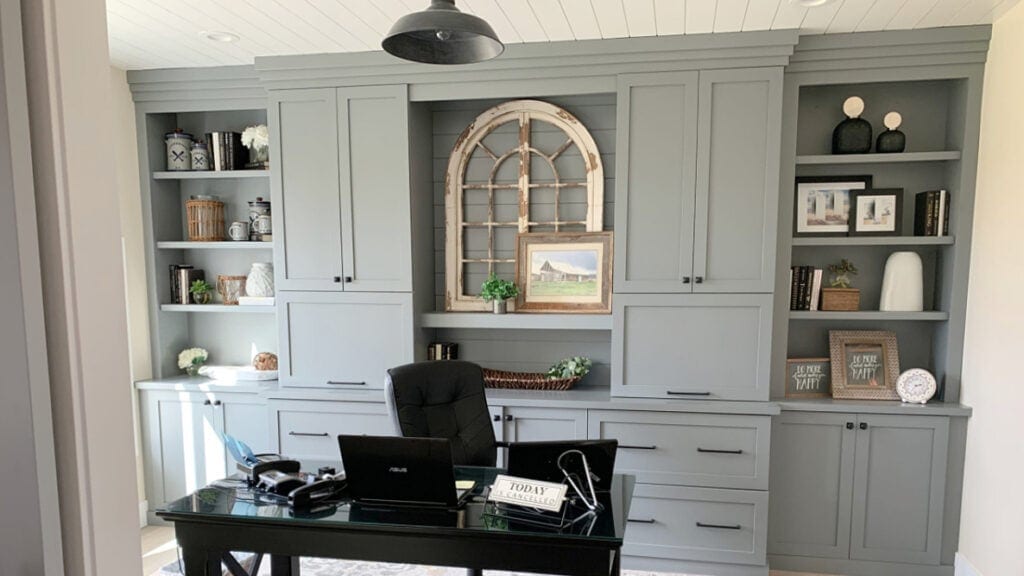 home office with Magnolia Teak Cups painted on the built-in cabinets, black desk