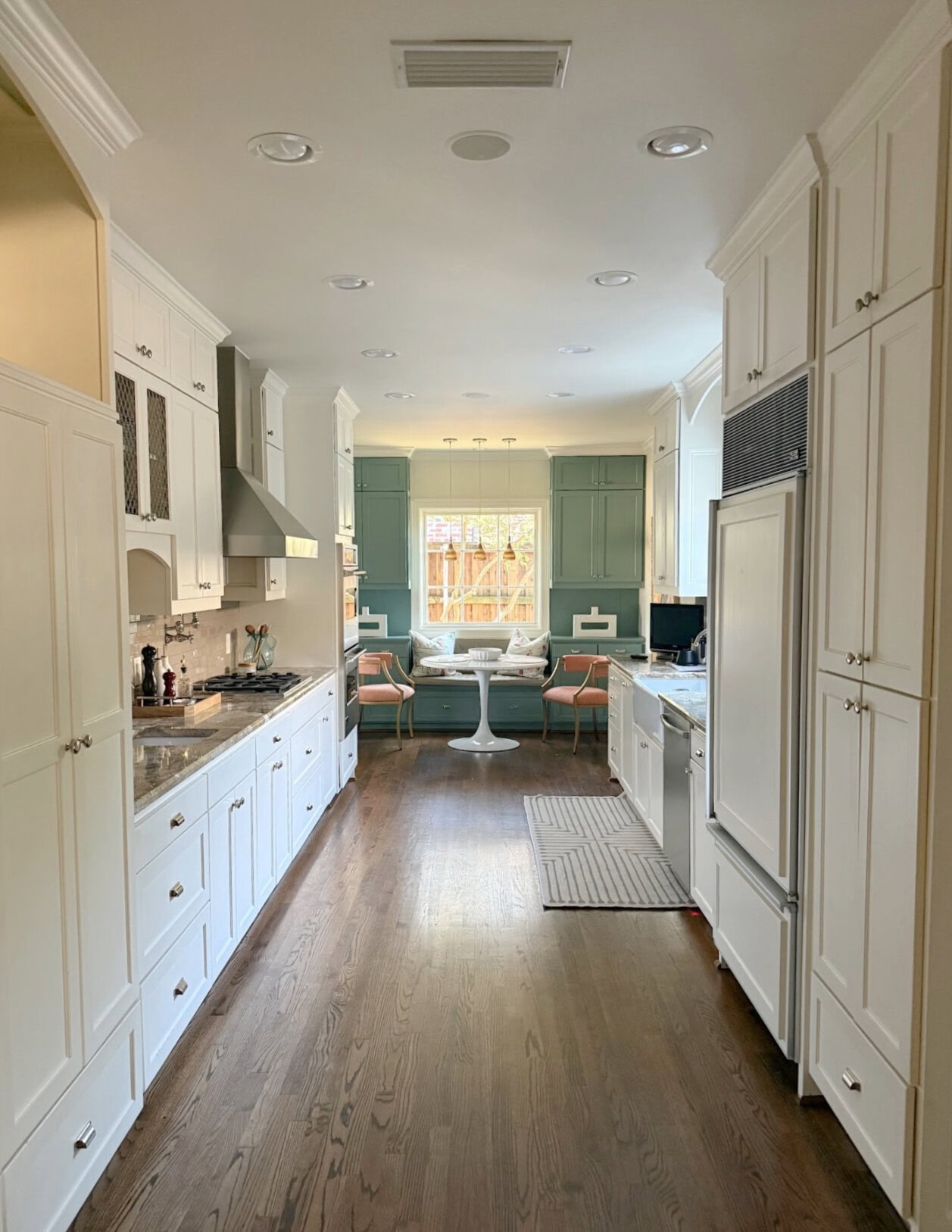 Sherwin Williams Underseas accent cabinets with Dover White kitchen cabinets, oak wood floor, 2000s granite countertop