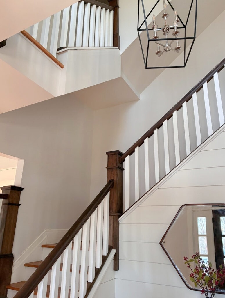 Sherwin Williams city Loft in staircase and entryway with shiplap white accent wall. wood hand railing, posts, white spindles, north facing