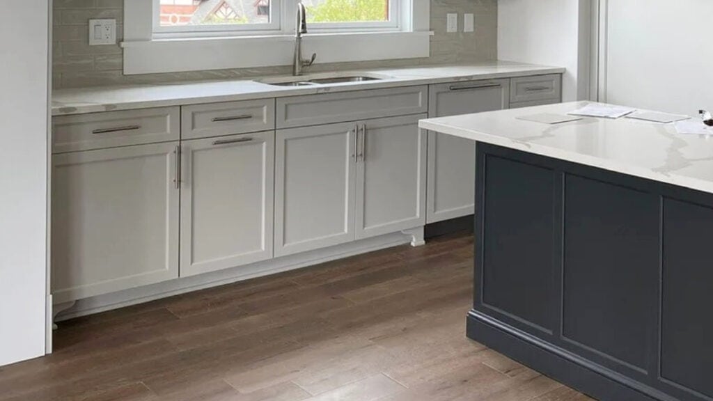 Sherwin Williams Agreeable GRay with coordinating paint color on island, Iron Ore (soft black) with white quartz and subway tile