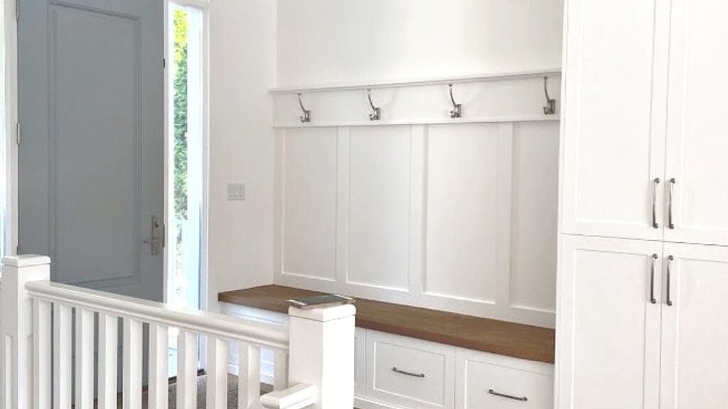 Sherwin Williams Gris on inside of front door, white oak floor and Benjamin Moore Super White bench and built-ins.