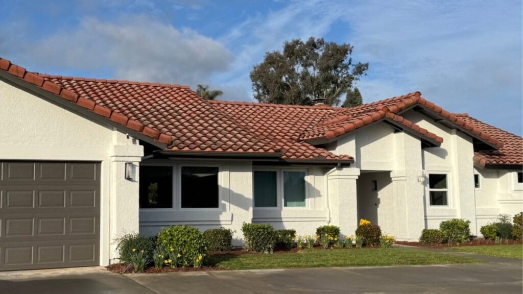 exterior warm creamy white paint color with red terracotta tile roof and dark greige garage door, white windows