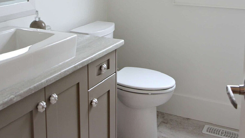 BENJAMIN MOORE KINGPORT GRAY IN A SMALL BATHROOM WITH A PAINTED VANITY AND LAMINATE COUNTERTOP