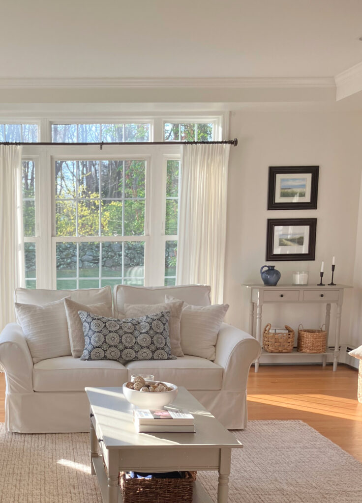BEnjamin MOore White Dove in south-facing living room, tray ceiling, matching trim, walls and ceiling, white sofa and home decor