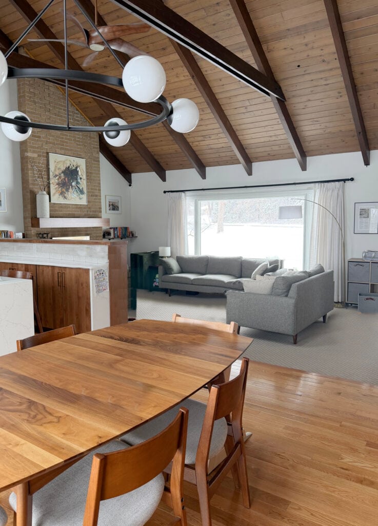 Beige brick fireplace with vaulted wood beams and ceiling, Mid-century modern living room with Pure White walls