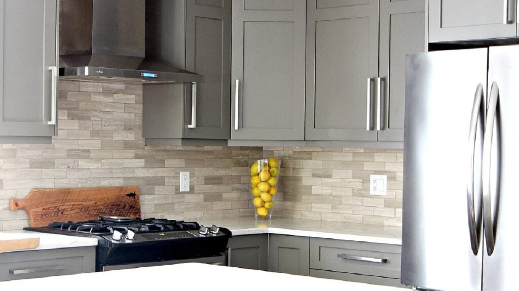 Benjamin Moore Amherst Gray painted kitchen cabinets, limestone tile backsplash and white quartz